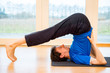 Man practicing yoga indoors in a retreat space doing Plow Pose - Halasana