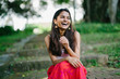 © Danon - Young Indian lady in a summer dress laughing in a park