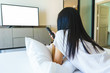 Asia woman relax on bed and watching television