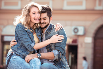 Canvas Print - Cheerful smiling couple in love hugging in the street.