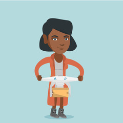 Sticker - Young african woman controlling delivery drone with post package. Woman getting post package from delivery drone. Woman sending parcel with delivery drone. Vector cartoon illustration. Square layout.