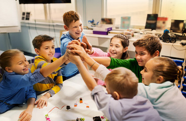 Wall Mural - happy children making high five at robotics school