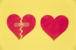 © artursfoto - Broken paper heart with patch next to the whole paper heart on yellow background. Rebuild relationship concept