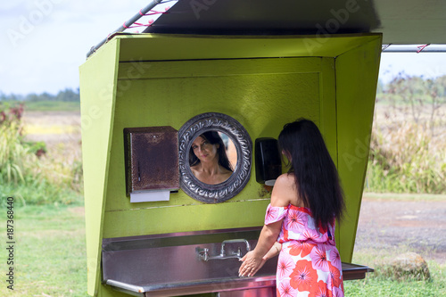 Fotografija Woman washing her hands reflected in a mirror