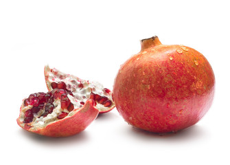 Pomegranate covered with water drops and 2 cut pieces of pomegranate isolated on white background