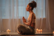 © Yakobchuk Olena - Profile of serene young woman sitting in lotus position while meditating. She is joining palms together