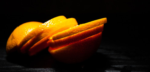 orange sliced on dark wooden background. with copy space.