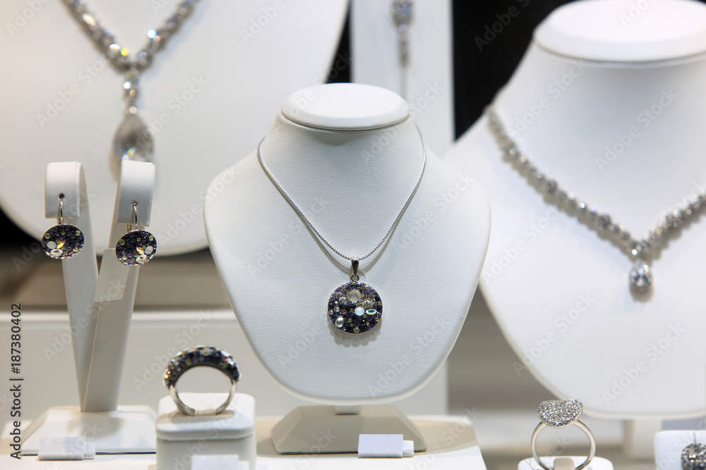 Srebrny naszyjnik, kolczyki i pierścień z diamentami na białych popiersiach w sklepie jubilerskim. - obrazy, fototapety, plakaty 