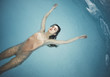 © Lumina/Stocksy - Woman Floating at Swimming Pool