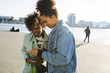 © Ivo de Bruijn/Stocksy - Two young black women, having fun with their phone.