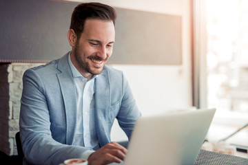 Portrait of young man sitting at his desk in the office.