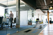 © Alicia Magnuson Photography/Stocksy - Man Working at Standing Desk in Glass-Walled Office
