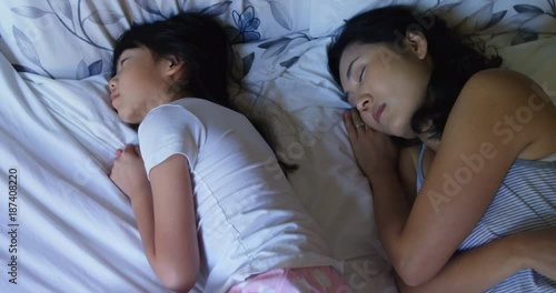 Stockvideo van Mother and daughter sleeping together in bedroom op Adobe St...