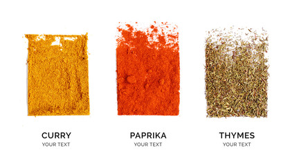 Wall Mural - Creative layout made of curry, paprika and thyme. Flat lay. Food concept. Thyme, paprika and curry powder on the white background