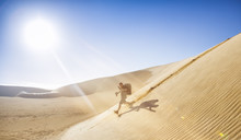 Phographer Running Down A Dunes