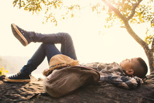 Boy Backpacker Sleeping On The Rock In Nature , Relax Time On Holiday Concept Travel,selective And Soft Focus,tone Of Hipster Style