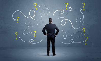 Wall Mural - Unsure businessman with question marks