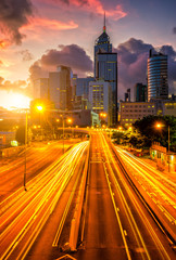 Fototapete - Traffic at central district in Hong Kong at sunrise time. Car light trails and urban cityscape in Hongkong city .