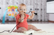 © Oksana Kuzmina - 8 months age baby curious looking at electronic plug