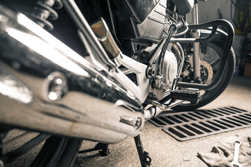 Wall Mural - Close up of man's hands with motorcycle in garage