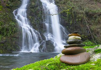 Harmony and balance, Rock Stack in front of waterfall. Urumea river in Basque Country.