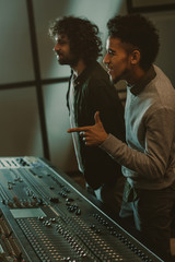 Poster - smiling young sound producers at recording studio