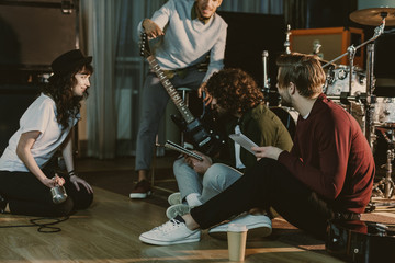 Wall Mural - music band sitting on floor and creating text for song together