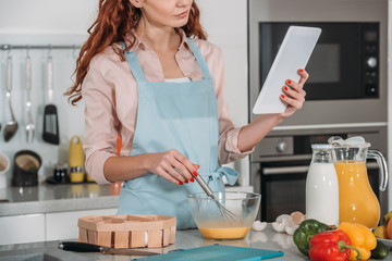 cropped image of woman looking at recipe for cooking