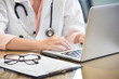 © eggeeggjiew - Female Doctor working with laptop.