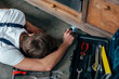 © LIGHTFIELD STUDIOS - high angle view of young repairman checking oven with flashlight