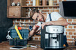 © LIGHTFIELD STUDIOS - professional young repairman in eyeglasses fixing coffee machine