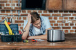 © LIGHTFIELD STUDIOS - frustrated young man in eyeglasses looking at broken toaster at home