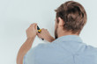 © LIGHTFIELD STUDIOS - back view of young foreman using pliers and taking off nail from wall
