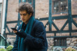 © Kike Arnaiz/ADDICTIVE STOCK - Young man browsing smartphone on street