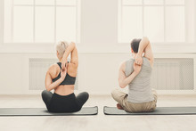 Young Couple In Yoga Class, Back Stretching