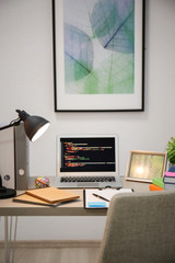 Comfortable workplace with laptop on desk at home