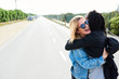 © Guille Faingold/Stocksy - Happy girlfriends hugging on road.