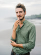 © Dreamwood - Mikhail & Ludmila/Stocksy - Handsome male posing on beach