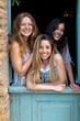 © Bisual Studio/Stocksy - Three cheerful females in doorway posing