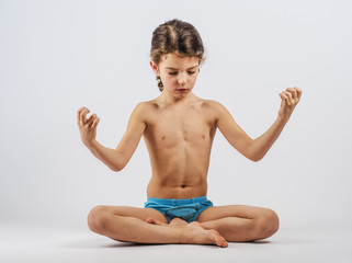 cute boy in swimming trunks doing gymnastic exercises.