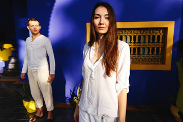 Wall Mural - Dreamy couple dressed in white closes walks around African city Marrakesh in a sunny evening