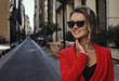 © xo4uphoto - woman in red suit and sun glasses smiling outdoors