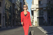 © xo4uphoto - woman in red suit and sun glasses walking at the street