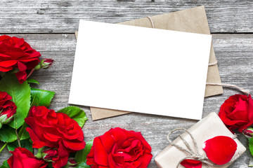 blank white greeting card with red rose flowers bouquet and envelope with gift box