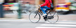 canvas print picture - bicycle rider in the city in motion blur