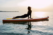 © Guille Faingold/Stocksy - Woman in wetsuit on sup.