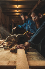 Two Carpenters Working In Workshop/sawmil With Wood.