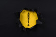 black torn paper revealing exclamation mark on yellow paper. exclamation mark background concept