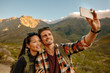 © Jacob Ammentorp Lund/Stocksy - Young couple hiking taking selfie with smart phone