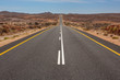 © Jonathan Caramanus/Stocksy - Long straight desert highway road stretching into the distance